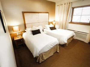 Belcoo海关大楼乡间旅馆的酒店客房设有两张床和窗户。