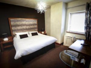 Belcoo海关大楼乡间旅馆的卧室配有一张白色大床和一张书桌