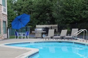 纽瓦克威尔明顿纽瓦克/克里斯蒂娜广场套房酒店的游泳池配有椅子和桌子及遮阳伞