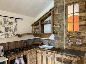 塞里纳Paradise La Tana的厨房配有木制橱柜和石墙