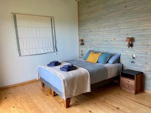 卡斯特鲁La Casa del Humedal的一间卧室设有一张床和木墙