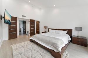洛杉矶Staycation in West Los Angeles的卧室配有一张带白色床单和地毯的大床。