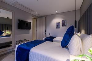 麦德林4 Sur Hotel的酒店客房设有两张床和电视。