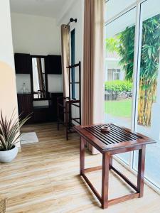 米瑞莎Lost Paradise Sri Lanka的一张木制咖啡桌,位于带大窗户的房间里