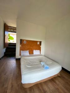 森纳儒森纳儒蜻蜓旅馆的卧室配有白色的床和木制床头板