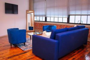 圣路易斯Cozy Stylish Downtown Loft的客厅配有蓝色的沙发和2把蓝色的椅子