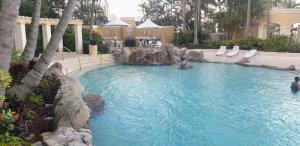 黄金海岸Bellagio@Chevron, Luxe, 2 Bedroom Apartment in the Heart of Surfers Paradise!的度假村的游泳池,带椅子和树木