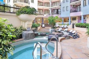 穆卢拉巴2 Bedroom Central Mooloolaba Resort with Pool, Spa, Mini Golf的庭院中设有游泳池的酒店