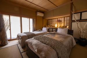 安昙野市Azumino Salon的带窗户的客房内的两张床