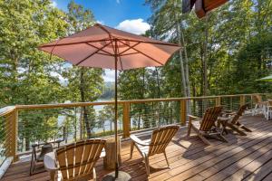 威尔克斯伯纳Lake Haven Lodge的露台配有椅子和遮阳伞,位于甲板上