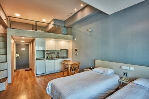 首尔Provista Hotel的一间大型客房,设有两张床和厨房