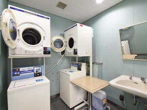 敦贺市新所皮亚敦贺酒店的一间医院间,配有洗衣机和水槽