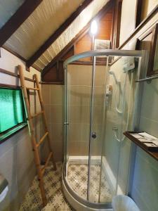 卡农Baan Thong Ching Resort的浴室里设有玻璃门淋浴