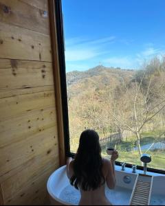 阿斯格罗Algreco Naturists & Swinging的坐在浴缸里,从窗户望出去的女人