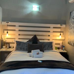 勒斯滕堡Meraki Upmarket Guesthouse的一间卧室配有一张大床和木制床头板