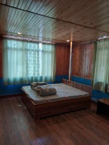 大吉岭Athithi homestay的木制客房内的一间卧室配有一张大床