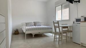 Beʼer Oraאירוח ליד אילת compliment near Eilat的白色的客房配有桌子、床和椅子