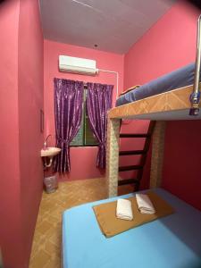 瓜拉勿述Rumah Hentian Ayah的卧室设有粉红色的墙壁和一张双层床。