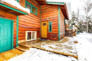 费尔班克斯Ideally Located Fairbanks Vacation Rental!的雪中带蓝色门的小木屋