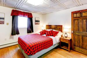 费尔班克斯Ideally Located Fairbanks Vacation Rental!的一间卧室配有一张带红 ⁇ 子毯子的床