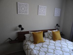 AlmogíaB&B Casa Sarandy的一间卧室配有一张带黄色枕头的床
