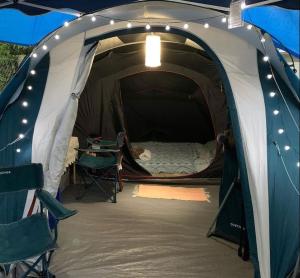 若阿诺波利斯Pousada camping Recanto Joanópolis的帐篷配有一张床和一张桌子