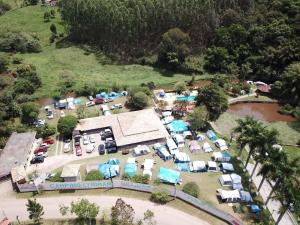若阿诺波利斯Pousada camping Recanto Joanópolis的享有停车场的空中景致,设有帐篷和汽车