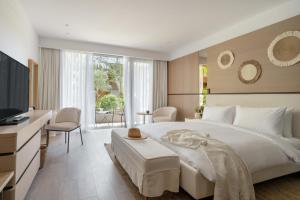 博德鲁姆METT Hotel & Beach Resort Bodrum的卧室配有一张白色大床和一张书桌