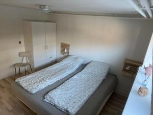海宁Hyggelig & lys kælderlejlighed的一间卧室配有两张床和椅子