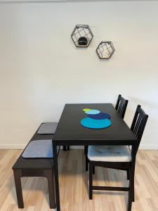海宁Hyggelig & lys kælderlejlighed的一张带两把椅子的黑桌和墙上的时钟