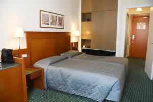 雅典阿德里安酒店的酒店客房,配有床和电视