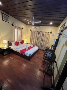 琅勃拉邦占城别墅的一间卧室配有一张带红色枕头的大床