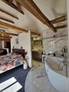 孔佩尔Le mas ROLLAND - Piscine & SPA - MILLAU-GORGES du TARN的主浴室设有浴缸和床。