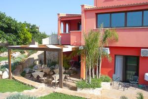 奥尼萨诺Pozzillo San Rocco的红色的建筑,设有配备桌椅的庭院