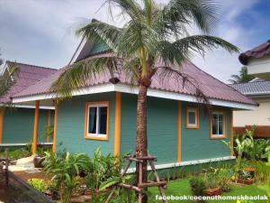蔻立考拉椰子屋假日公园的一座绿屋,前面有棕榈树