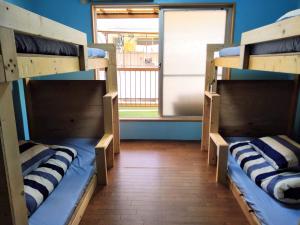 神户TONARINO Hostel for Backpackers的带窗户的客房内的两张双层床