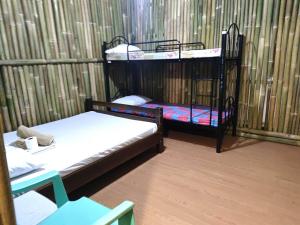 巴旺Bella's Beach Resort Apartment 8的带围栏的客房内的两张双层床