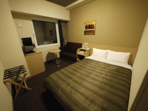 石卷市石卷中央路线酒店的酒店客房,配有床和沙发