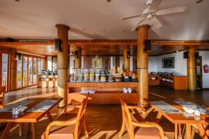卡伦海滩卡隆普纳卡度假酒店的一间带木桌椅的餐厅和一间酒吧