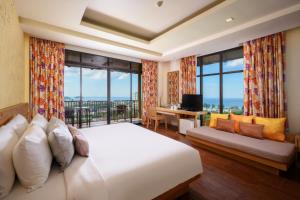 卡伦海滩卡隆普纳卡度假酒店的一间带大床的卧室和一个阳台