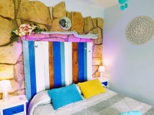 罗夫莱多德查韦拉AlmenaraLove Bellaluna的一间卧室配有一张带岩石墙的床