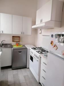 加利波利Valerie Apartment的厨房配有白色橱柜和炉灶烤箱。