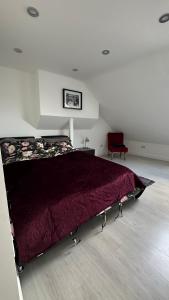 伦敦Stunning new 1 bedroom apartment的一间卧室配有一张红色棉被的床