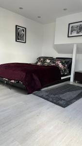 伦敦Stunning new 1 bedroom apartment的一间卧室配有一张床铺,床上铺有紫色毯子