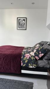 伦敦Stunning new 1 bedroom apartment的一张带紫色床罩的床,墙上挂着一张照片