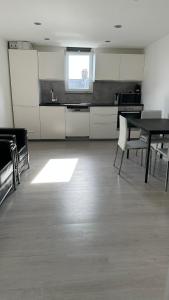 伦敦Stunning new 1 bedroom apartment的一间空厨房,里面配有桌椅
