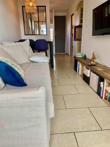 滨海圣西尔La Frégate - appartement à 100 m de la plage的带沙发和瓷砖地板的客厅