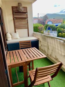 滨海圣西尔La Frégate - appartement à 100 m de la plage的阳台配有一张木桌和椅子,提供一张床