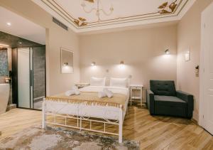 雅典Neapolis 1897 Boutique Luxury Rooms的一间卧室配有一张床和一把绿色椅子