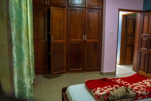 BueaPlan B Complex的一间卧室配有木制橱柜和一张带红色毯子的床。